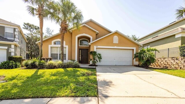 2805 Lido Key Ct, Kissimmee, FL 34747 - mediterranean / spanish-style house featuring stucco siding, an attached garage, and driveway