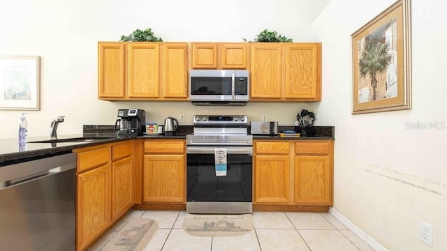 2805 Lido Key Ct, Kissimmee, FL 34747 - kitchen with stainless steel appliances, a sink, light tile patterned floors, and dark stone countertops