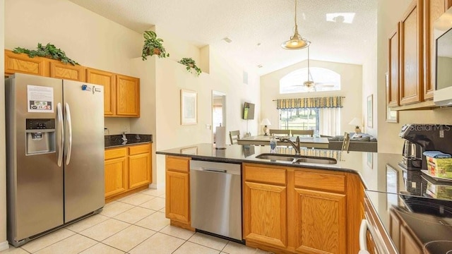 2805 Lido Key Ct, Kissimmee, FL 34747 - kitchen featuring appliances with stainless steel finishes, a sink, vaulted ceiling, a peninsula, and light tile patterned flooring