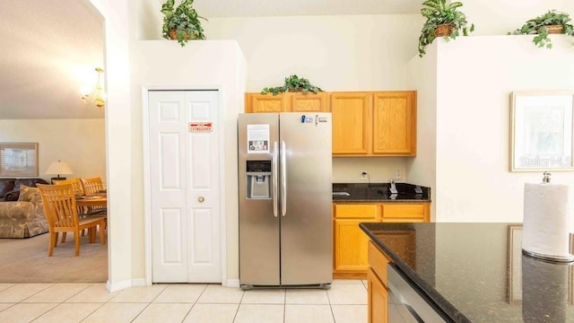 2805 Lido Key Ct, Kissimmee, FL 34747 - kitchen with stainless steel fridge, light tile patterned floors, dark stone countertops, and light carpet