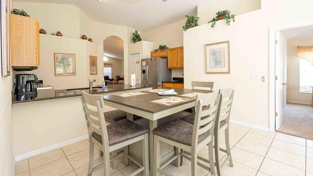 2805 Lido Key Ct, Kissimmee, FL 34747 - dining room with light tile patterned floors, arched walkways, lofted ceiling, and baseboards