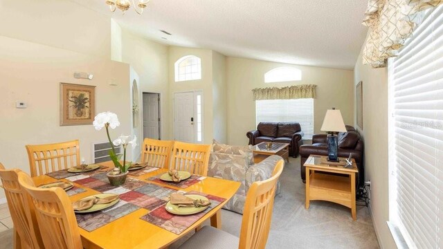 2805 Lido Key Ct, Kissimmee, FL 34747 - carpeted dining area with lofted ceiling and a textured ceiling