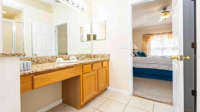 2805 Lido Key Ct, Kissimmee, FL 34747 - ensuite bathroom featuring tile patterned flooring, vanity, a stall shower, ceiling fan, and baseboards