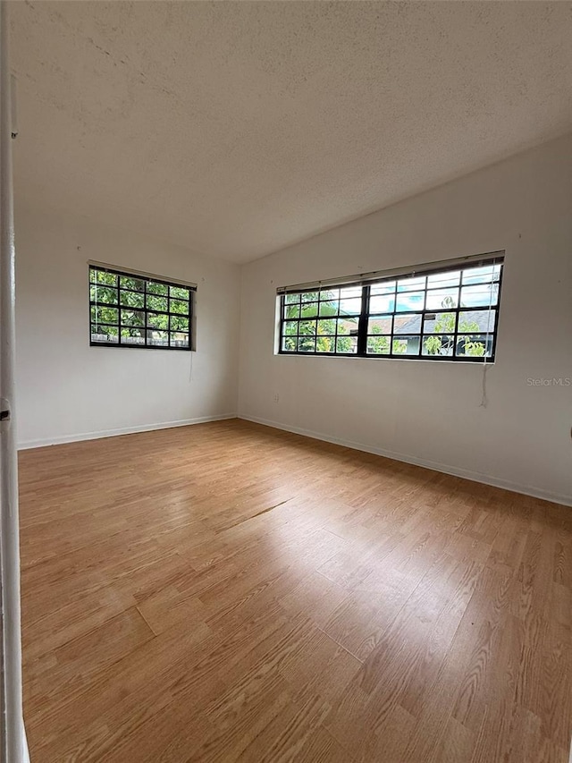 6615 Beamer Way, Orlando, FL 32807 - spare room with light wood finished floors, a textured ceiling, and baseboards