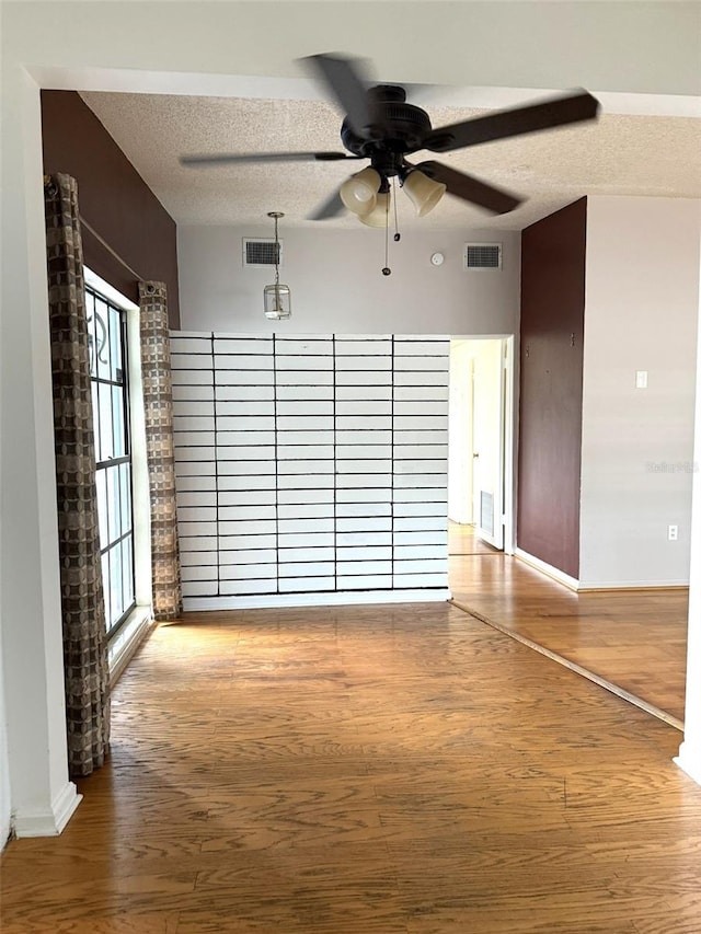 6615 Beamer Way, Orlando, FL 32807 - empty room with wood finished floors, ceiling fan, baseboards, and a textured ceiling