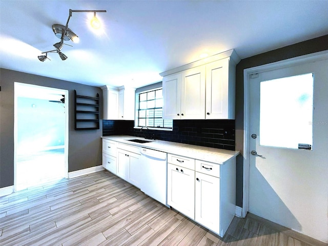 6615 Beamer Way, Orlando, FL 32807 - kitchen with white dishwasher, a sink, baseboards, light countertops, and white cabinetry