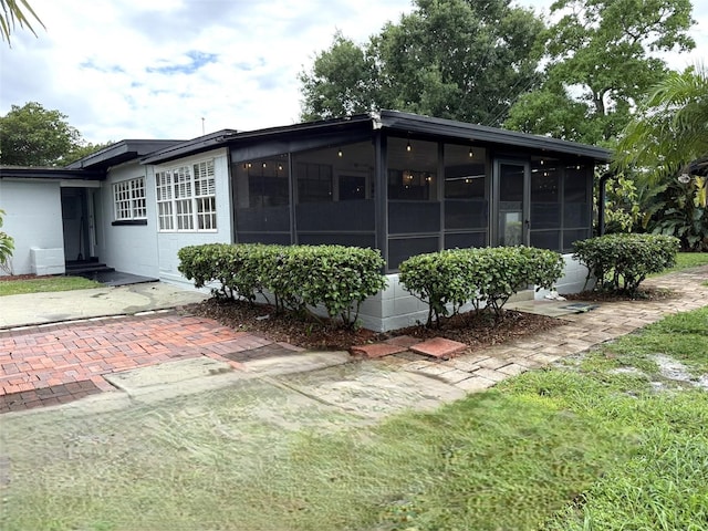 6615 Beamer Way, Orlando, FL 32807 - rear view of house featuring a sunroom, concrete block siding, and entry steps