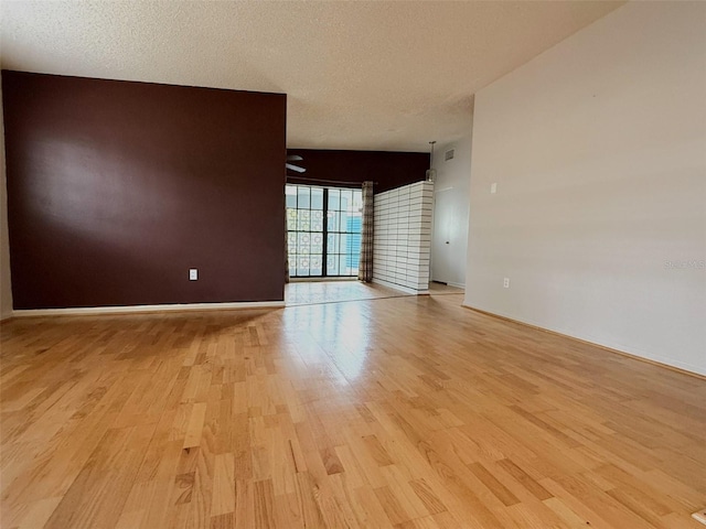 6615 Beamer Way, Orlando, FL 32807 - unfurnished room with light wood-style floors, baseboards, and a textured ceiling