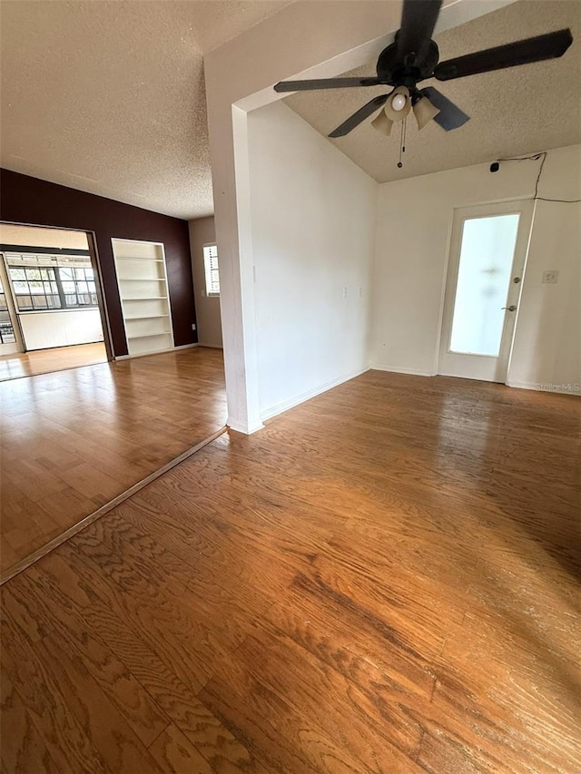 6615 Beamer Way, Orlando, FL 32807 - spare room with plenty of natural light, a textured ceiling, a ceiling fan, wood finished floors, and lofted ceiling