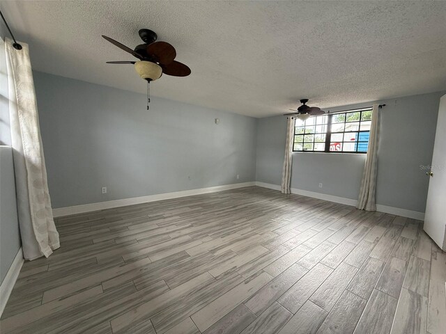 6615 Beamer Way, Orlando, FL 32807 - empty room with ceiling fan, a textured ceiling, wood finished floors, and baseboards