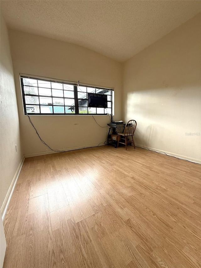 6615 Beamer Way, Orlando, FL 32807 - empty room featuring light wood-style flooring, a textured ceiling, and baseboards