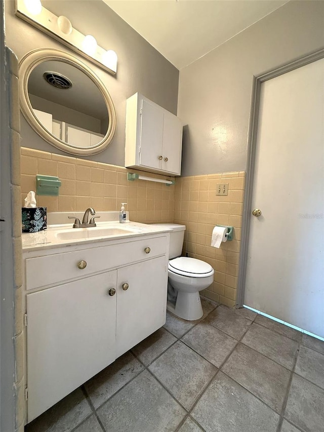6615 Beamer Way, Orlando, FL 32807 - bathroom with tile walls, tile patterned floors, toilet, a wainscoted wall, and vanity