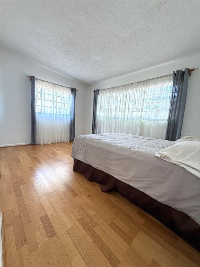6615 Beamer Way, Orlando, FL 32807 - bedroom with a textured ceiling and light wood-style floors