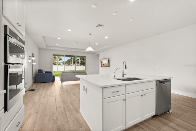 3635 Arbordale Loop, Sanford, FL 32771 - kitchen featuring a sink, appliances with stainless steel finishes, open floor plan, light wood-style floors, and an island with sink