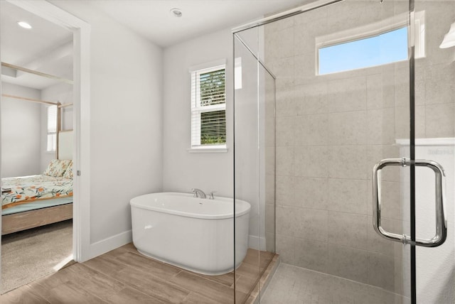 3635 Arbordale Loop, Sanford, FL 32771 - ensuite bathroom featuring wood finished floors, a stall shower, a soaking tub, baseboards, and recessed lighting