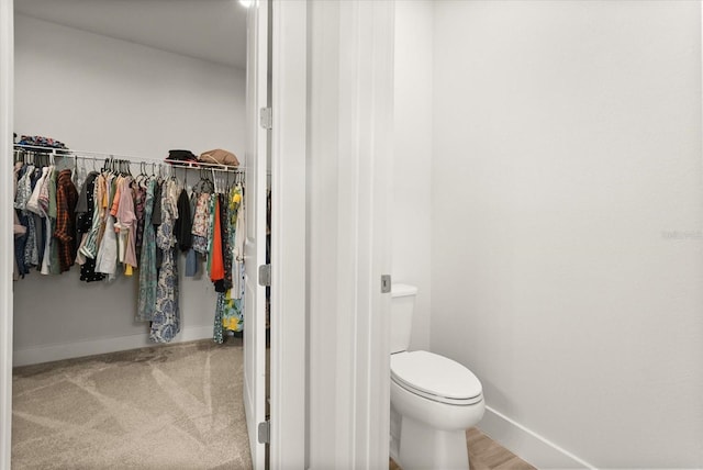 3635 Arbordale Loop, Sanford, FL 32771 - bathroom featuring baseboards, a walk in closet, and toilet