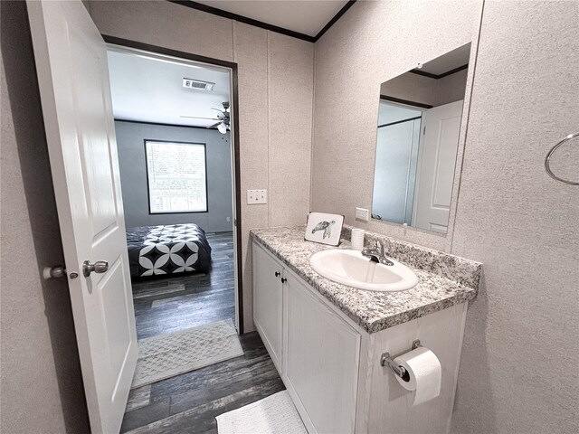3790 NW 4th Ave, Okeechobee, FL 34972 - bathroom featuring a textured wall, wood finished floors, vanity, and crown molding