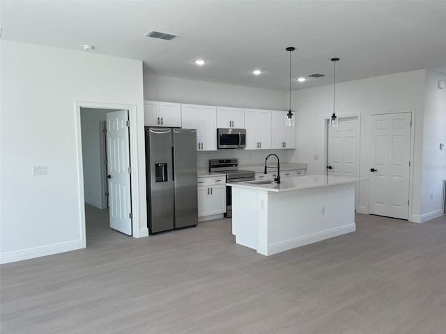5153 SW 159th St, Ocala, FL 34473 - kitchen with stainless steel appliances, a sink, light wood-type flooring, white cabinets, and recessed lighting