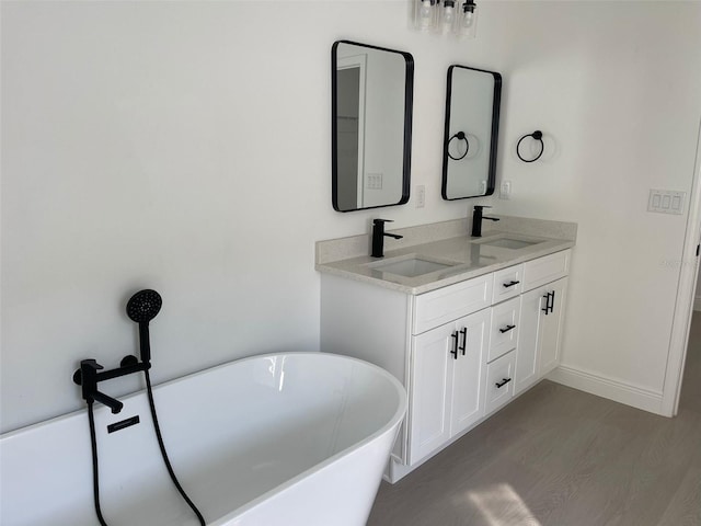 5153 SW 159th St, Ocala, FL 34473 - full bathroom featuring a freestanding bath, double vanity, baseboards, and wood finished floors