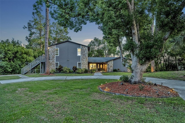 277 Sunrise Pt, Lake Mary, FL 32746 - mid-century home featuring curved driveway, a yard, and stone siding