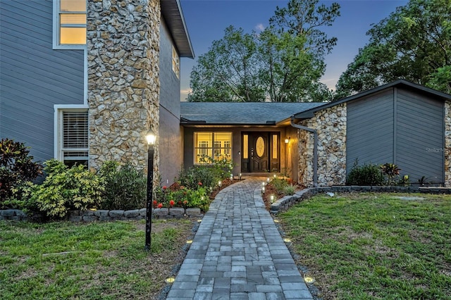 277 Sunrise Pt, Lake Mary, FL 32746 - property entrance with stone siding, a lawn, and a shingled roof