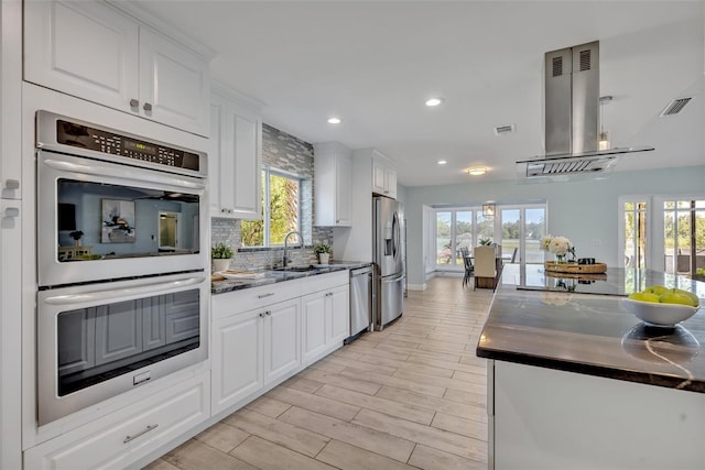 277 Sunrise Pt, Lake Mary, FL 32746 - kitchen featuring appliances with stainless steel finishes, island range hood, a sink, backsplash, and recessed lighting