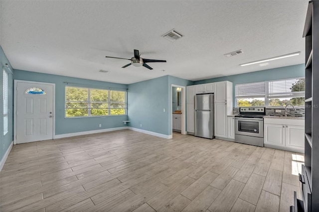 277 Sunrise Pt, Lake Mary, FL 32746 - kitchen featuring appliances with stainless steel finishes, ceiling fan, white cabinetry, a sink, and light wood-type flooring