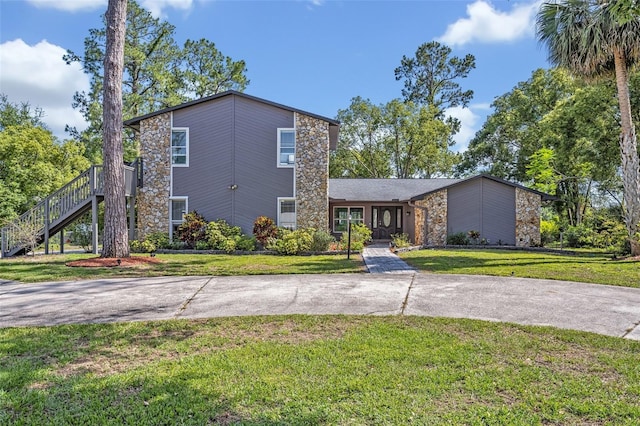 277 Sunrise Pt, Lake Mary, FL 32746 - mid-century home with stone siding, a front lawn, and stairs
