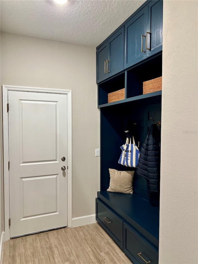 1266 Spotted Sandpiper Loop, Winter Springs, FL 32708 - mudroom with light wood-style floors, baseboards, and a textured ceiling