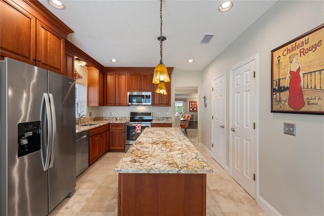 5973 Chesapeake Park Unit 58, Orlando, FL 32819 - kitchen with appliances with stainless steel finishes, a center island, light stone counters, decorative light fixtures, and recessed lighting