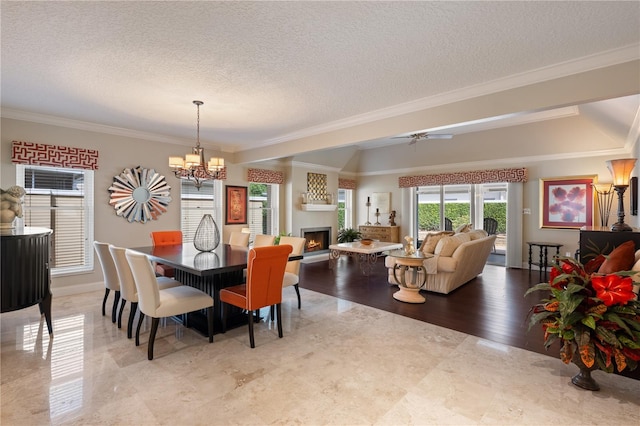 5973 Chesapeake Park Unit 58, Orlando, FL 32819 - dining room featuring a chandelier, a warm lit fireplace, crown molding, a textured ceiling, and a ceiling fan