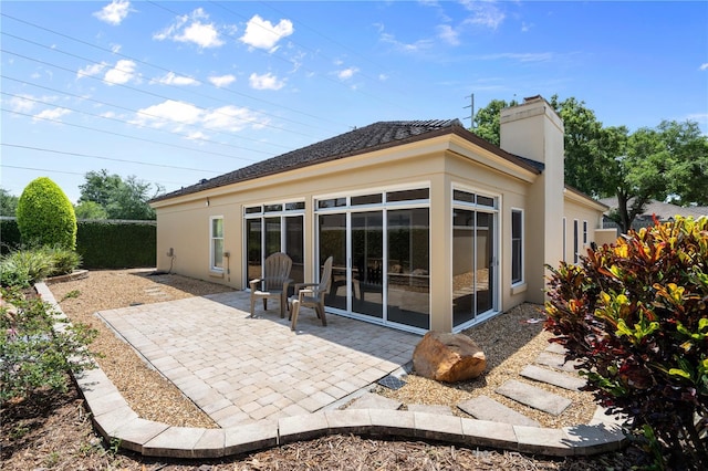 5973 Chesapeake Park Unit 58, Orlando, FL 32819 - rear view of house with a patio area, stucco siding, and a chimney