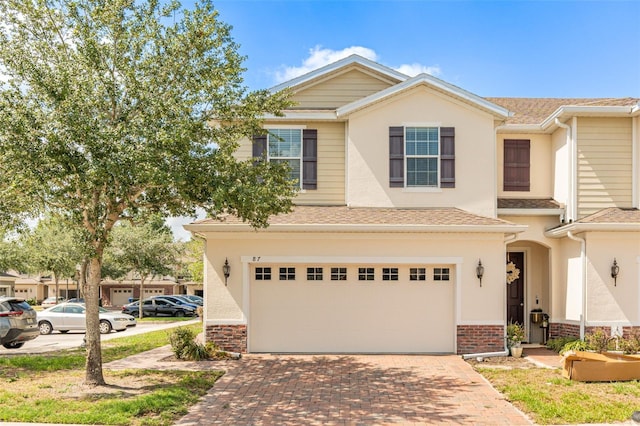 87 Delacorte Way, Oviedo, FL 32765 - multi unit property featuring a garage, decorative driveway, stucco siding, and a shingled roof