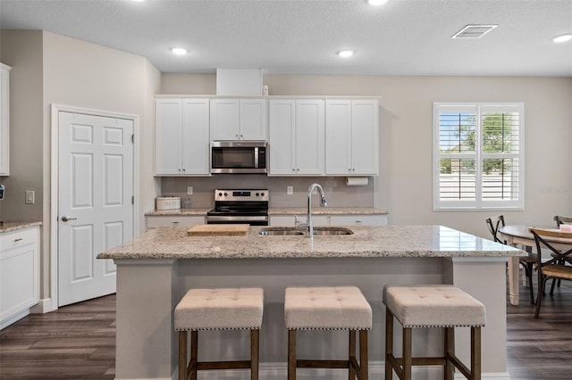 4811 SW 108th Place Rd, Ocala, FL 34476 - kitchen featuring stainless steel appliances, a sink, dark wood-type flooring, a breakfast bar, and recessed lighting