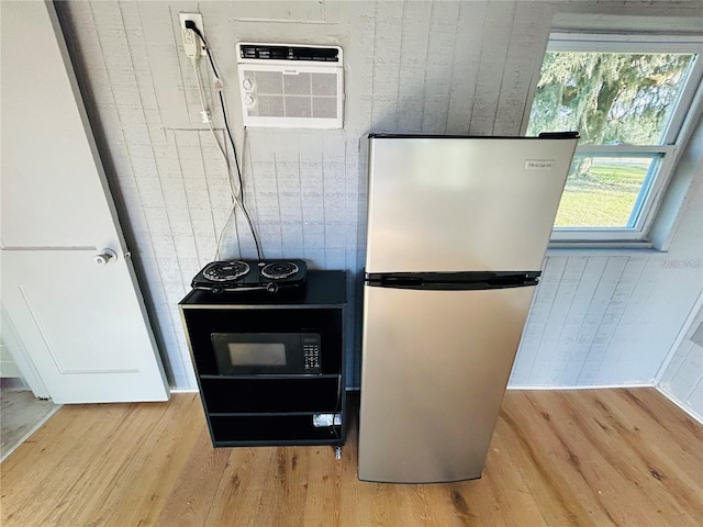 7904AND8010 SE US Highway 301, Hawthorne, FL 32640 - kitchen featuring freestanding refrigerator, wood finished floors, black microwave, and a wall mounted air conditioner