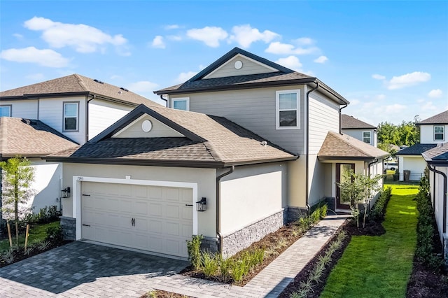 7745 Somersworth Dr, Kissimmee, FL 34747 - traditional home featuring a shingled roof, an attached garage, stucco siding, and stone siding