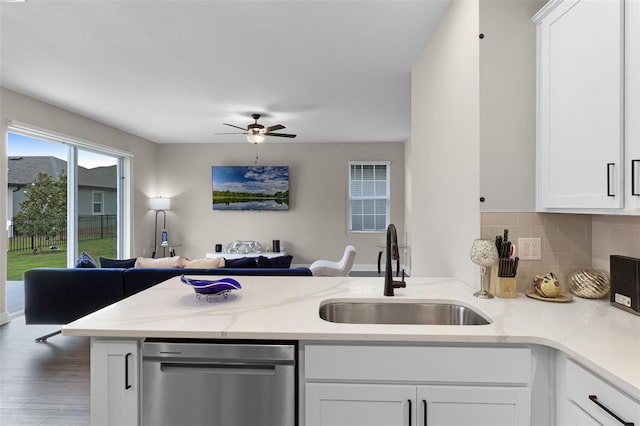 7745 Somersworth Dr, Kissimmee, FL 34747 - kitchen with stainless steel dishwasher, a sink, open floor plan, a peninsula, and decorative backsplash