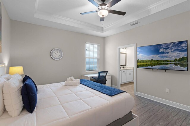 7745 Somersworth Dr, Kissimmee, FL 34747 - bedroom with a tray ceiling, wood finished floors, crown molding, baseboards, and connected bathroom