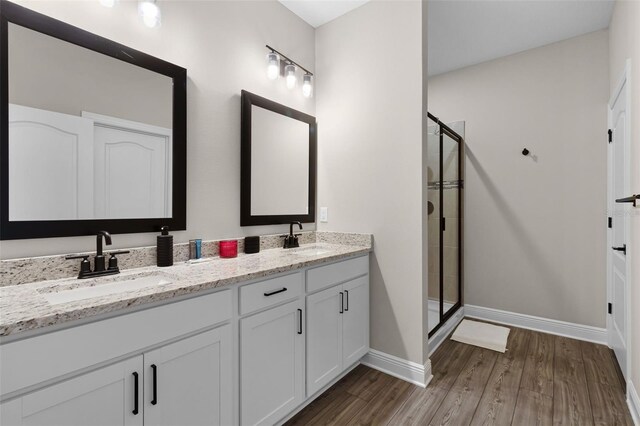 7745 Somersworth Dr, Kissimmee, FL 34747 - full bath featuring a shower stall, double vanity, wood finished floors, and baseboards