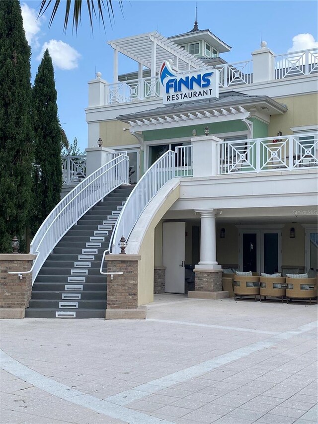 7745 Somersworth Dr, Kissimmee, FL 34747 - view of front of house featuring stairway, a balcony, and stucco siding