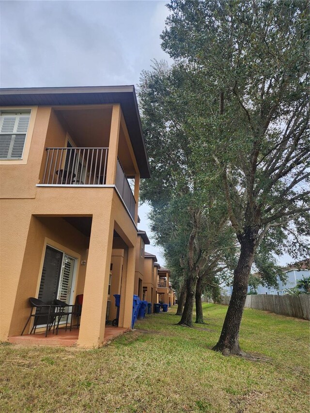 3500 Calabria Ave, Davenport, FL 33897 - rear view of property featuring a balcony, stucco siding, and a patio