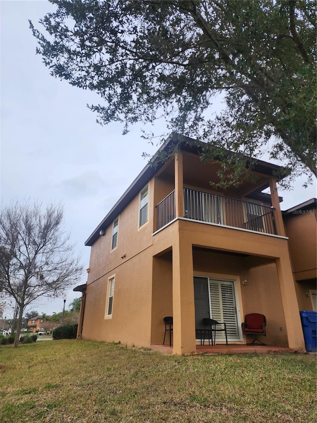 3500 Calabria Ave, Davenport, FL 33897 - rear view of property with a balcony, stucco siding, a lawn, and a patio area