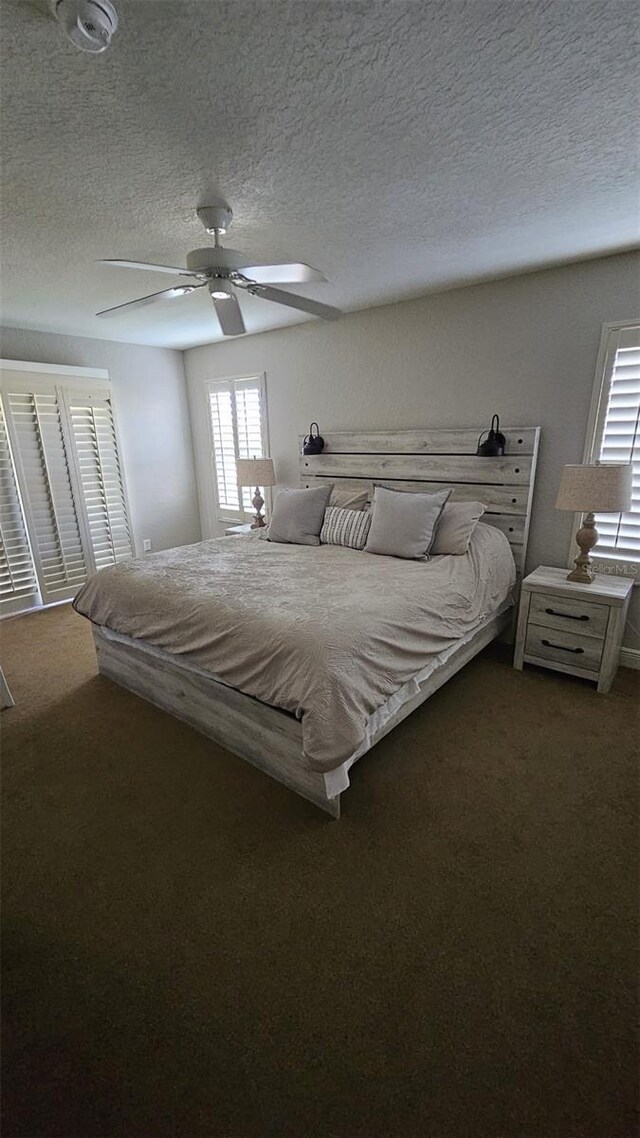 3500 Calabria Ave, Davenport, FL 33897 - bedroom with a textured ceiling, dark colored carpet, and a ceiling fan