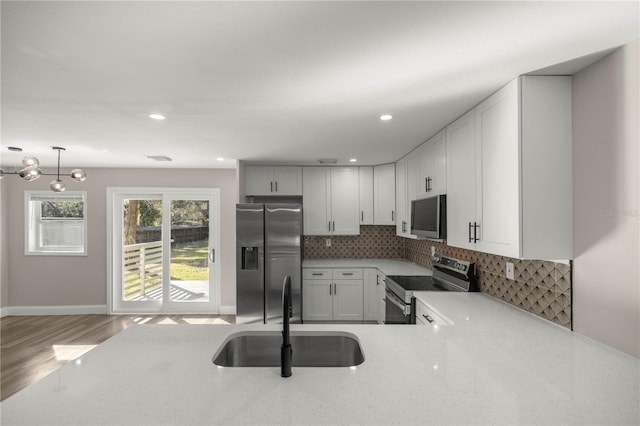 11572 SE 60th Ave, Belleview, FL 34420 - kitchen with appliances with stainless steel finishes, a sink, decorative backsplash, wood finished floors, and recessed lighting