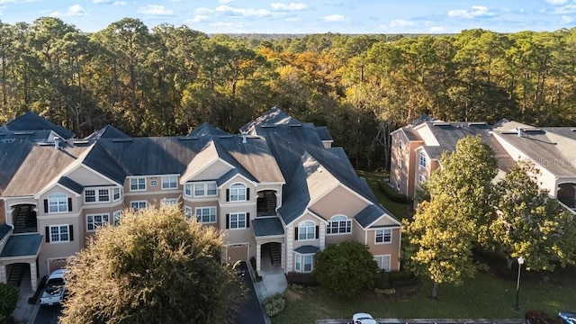 aerial view of property and surrounding area with a heavily wooded area