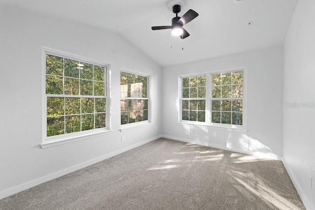 spare room featuring carpet flooring, lofted ceiling, baseboards, and ceiling fan