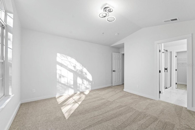 unfurnished bedroom featuring carpet floors, lofted ceiling, and baseboards