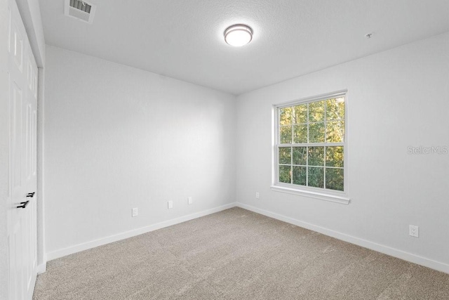carpeted empty room featuring baseboards