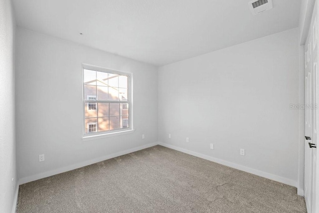 empty room featuring carpet flooring and baseboards