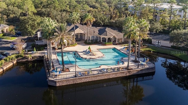 community pool with a patio and a water view